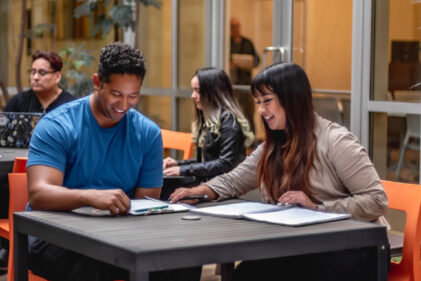 man in blue shirt working with woman
