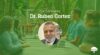 Dr. Ruben Cortez smiles in a portrait photo inset on a green banner image under text displaying his name.