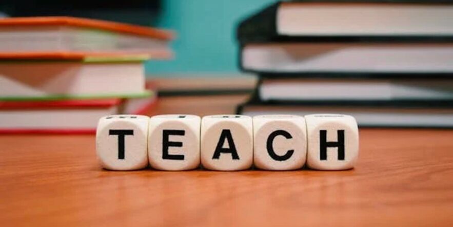 Five small, wooden blocks bearing the letters T, E, A, C and H spell out the word "teach."