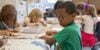 Young children doing homework at a table.