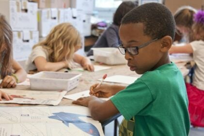 Young children doing homework at a table.