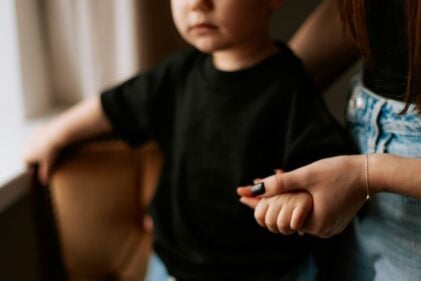 Small child holding the hand of an adult