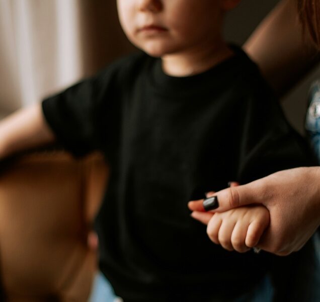 Small child holding the hand of an adult