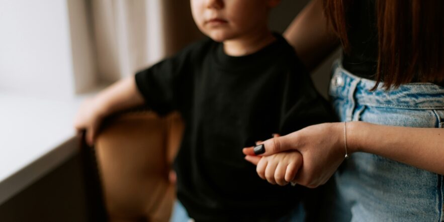 Small child holding the hand of an adult