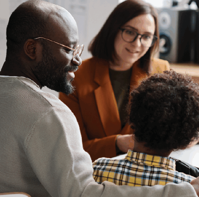 A woman and man talk to young boy
