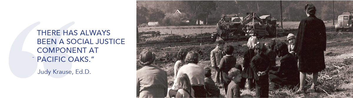 Black and white photo of children and adults standing with construction equipment in background.