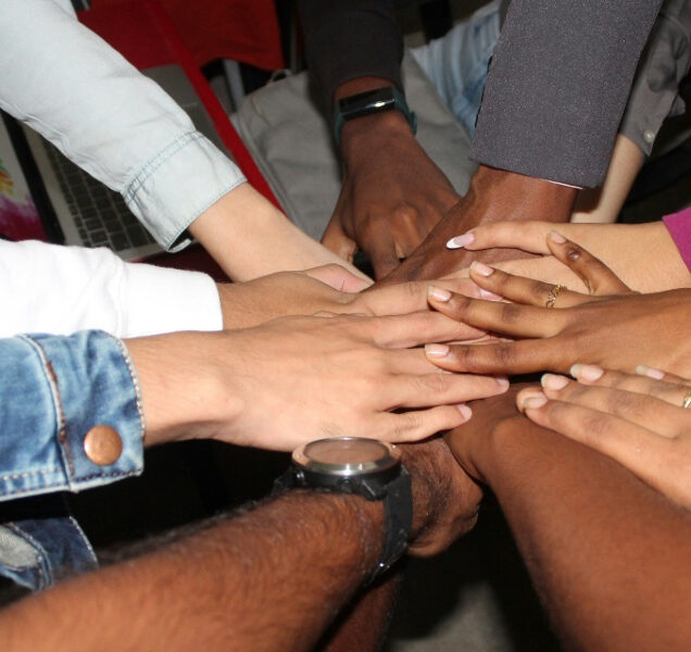 A circle of hands joined together.