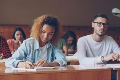 A male and female student in a lecture hall.
