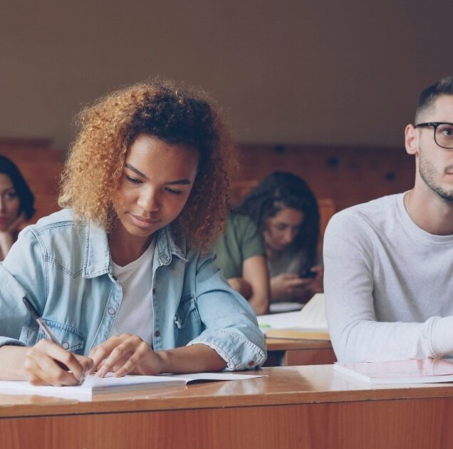 A male and female student in a lecture hall.