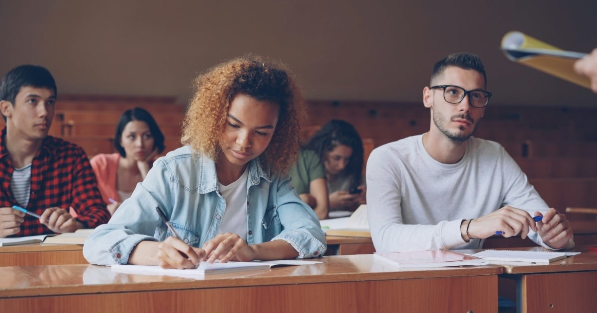 A male and female student in a lecture hall.
