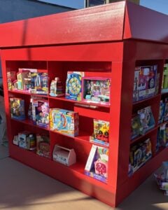 A large red box with shelves containing toys.
