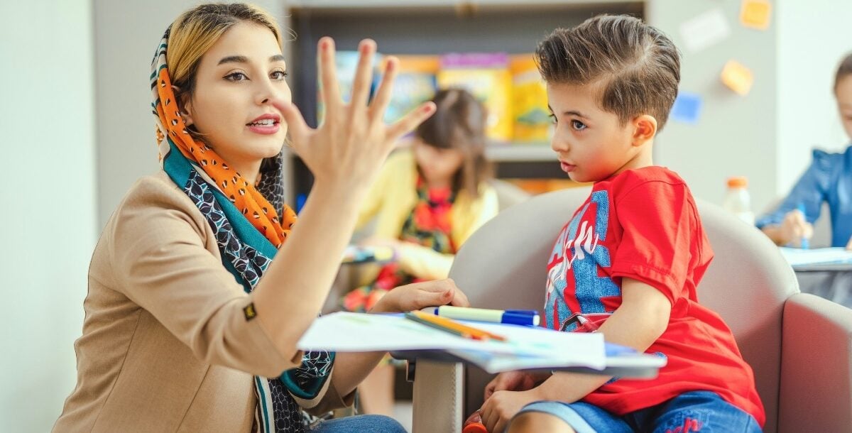 Tacher interacting with child in a classroom