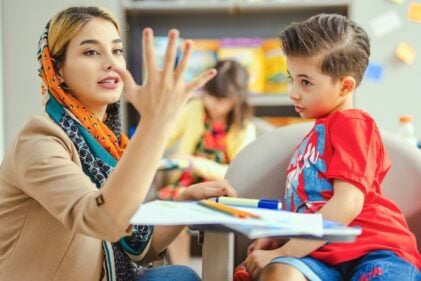 Tacher interacting with child in a classroom