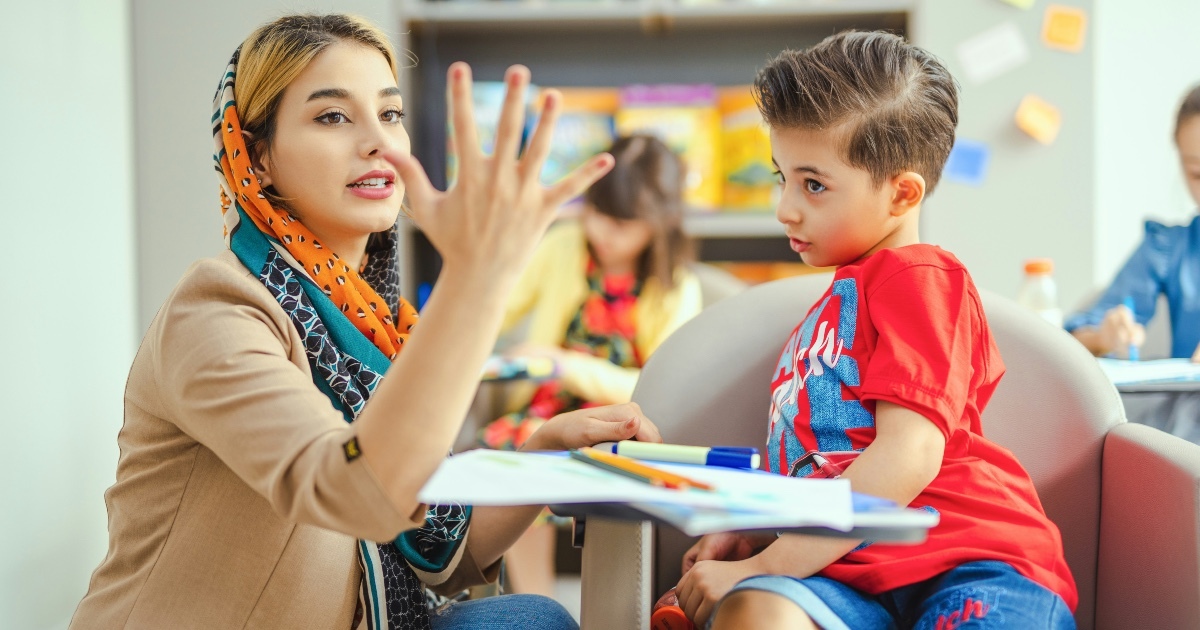 Tacher interacting with child in a classroom