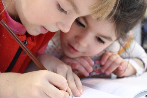 Children working on coursework provided by their child development instructor.