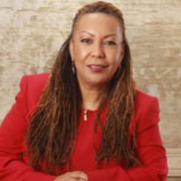 Professional woman posing for photo wearing a red blazer and top