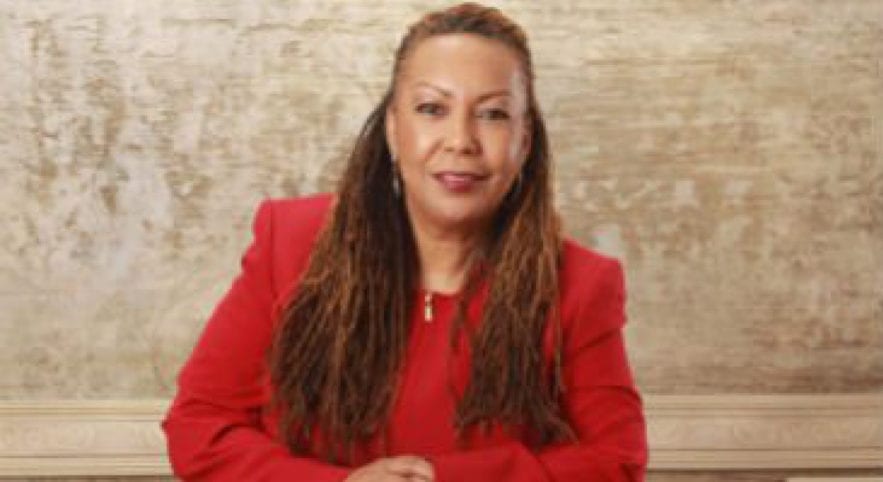Professional woman posing for photo wearing a red blazer and top