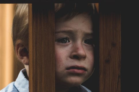 Child behind wooden posts