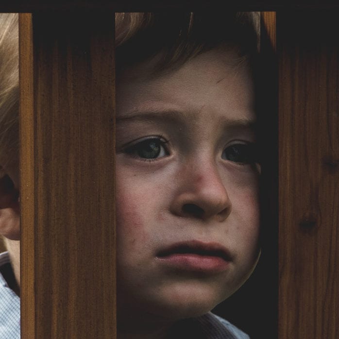 Child behind wooden posts