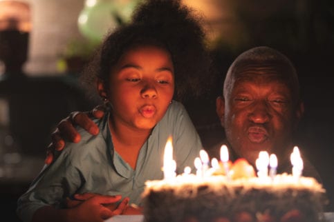 man and child blowing candles