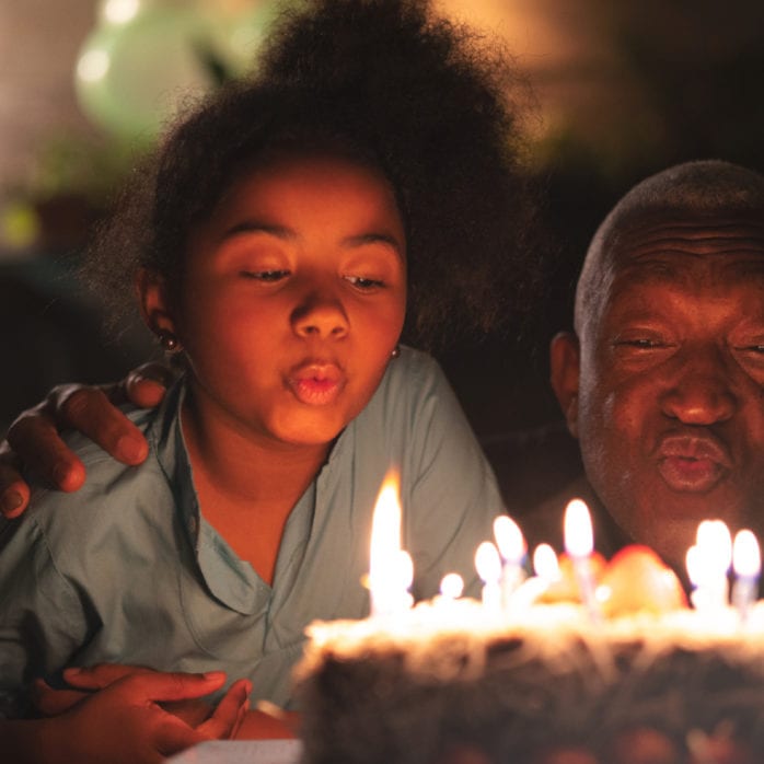 man and child blowing candles