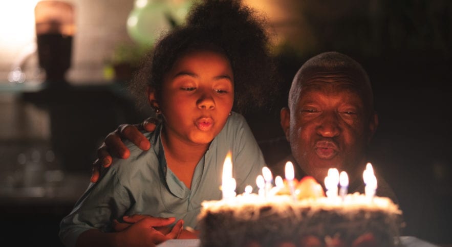 man and child blowing candles