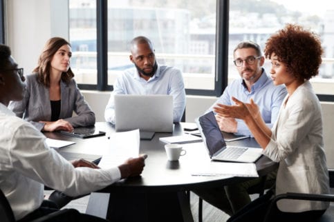 adults talking at board room table