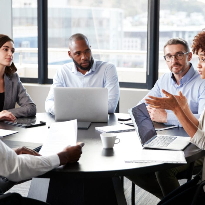 adults talking at board room table