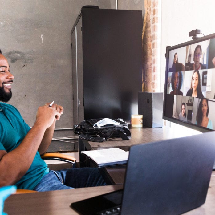 man working from home office while on conference call