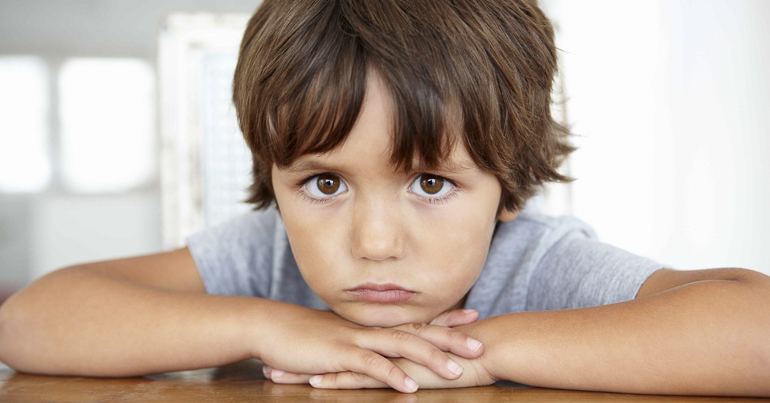 a sad student frowning at a desk
