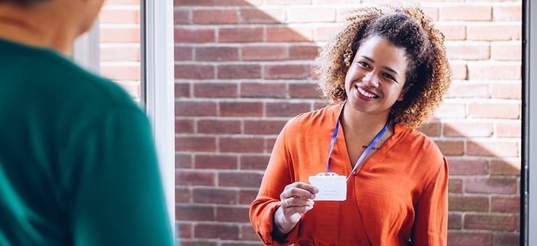 Woman smiling and holding her nametag