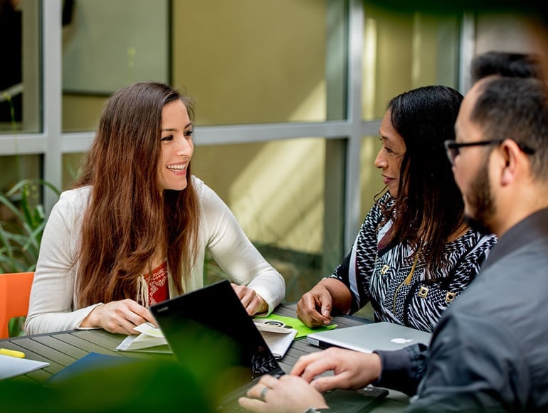 Two woman having a discussion with another student