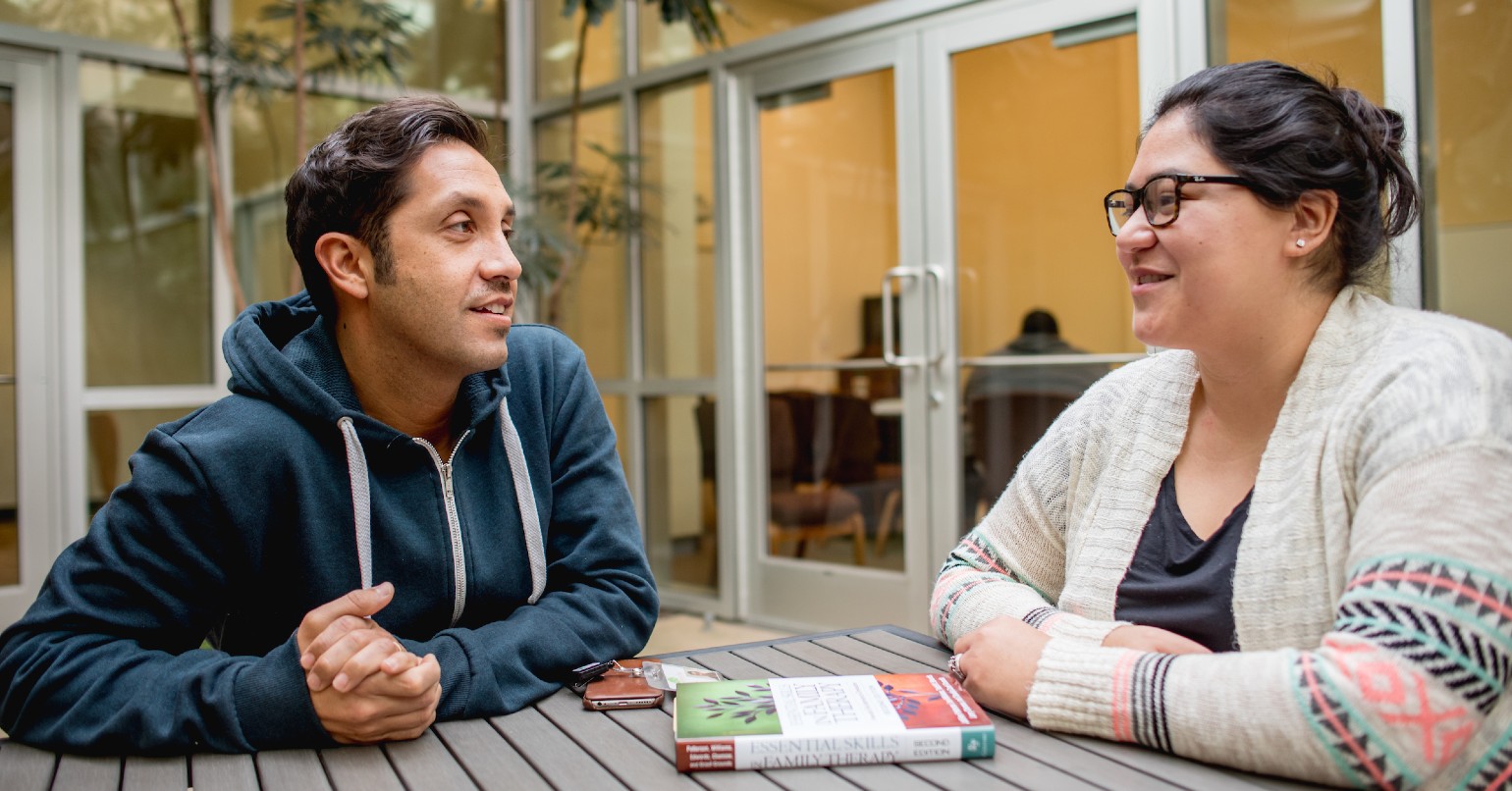 Male and female talking at a table