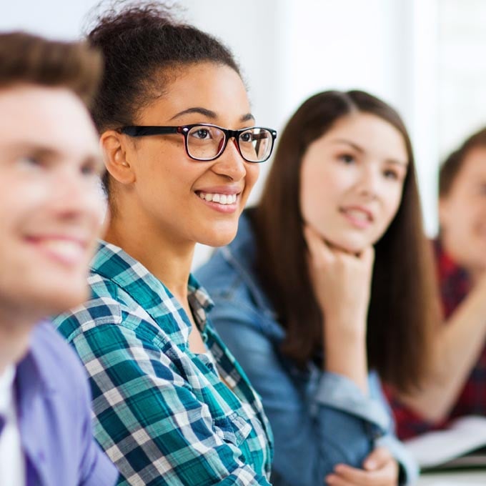 students smiling and listening in classroom